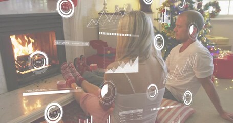 Fire flickering initiating data HUD as couple warming feet and sipping mugs by holiday fireplace - Powered by Adobe