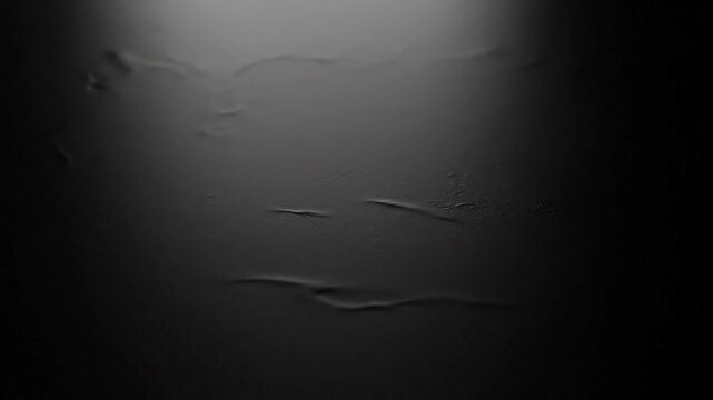 A mysterious dark textured background with subtle wrinkles and creases illuminated from above.