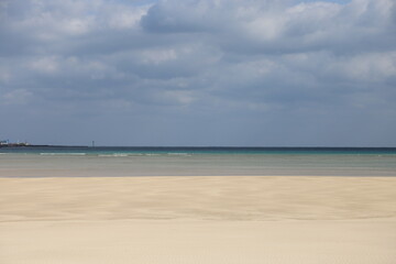제주도 해수욕장, 흐린 날씨 속 유달리 반짝이는 모래사장, 대비되지만 눈부시다.