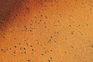 Rusty metal background in brown, red and orange colors. Rusty métal with particles and texture. Grainy rust and construction industry. Canvas and pattern in metallic texture.