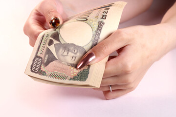 1万円札と女性の手