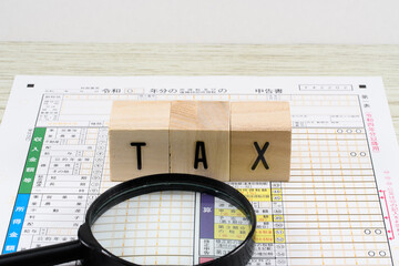 確定申告書と虫眼鏡で税務調査のイメージ