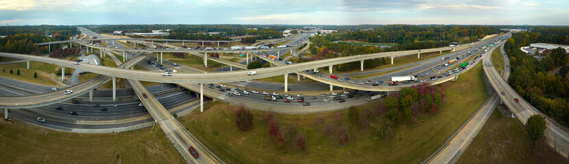 Fototapeta premium Aerial view of american freeway intersection with fast moving cars and trucks. USA transportation infrastructure concept