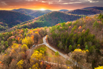 Car driving along mountain road surrounded by colorful autumn trees in Tennessee. Scenic road trip...