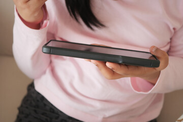 Child using phone while sitting on couch at home
