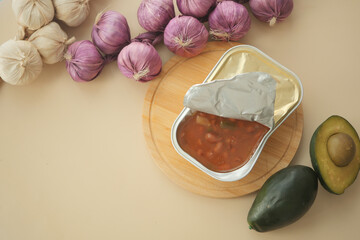 Canned Meal in Open Tin With Tomato Sauce and Fresh Avocado on Wooden Board