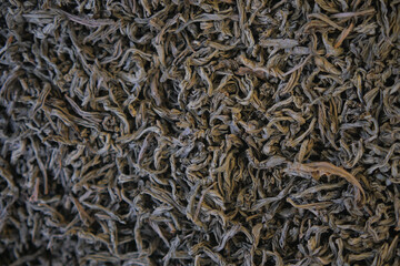 Dried tea leaves spread out for drying in a warm space