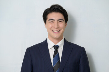 白背景で微笑む日本人男性