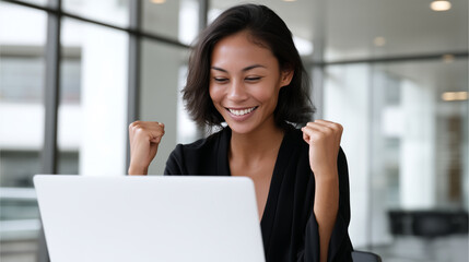 Obraz premium Cheering Asian businesswoman celebrating success in modern office