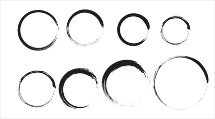 Collection of abstract hand painted black ink circles and rings with textured brush strokes on white background