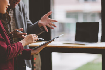 Business professionals collaborating on digital strategy using tablet
