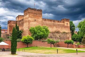 Ancient fortress, dramatic sky, park setting