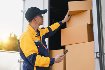 Delivery Worker Organizing Packages in Delivery Truck During Sunset with Smartphone in Hand for Inventory Management
