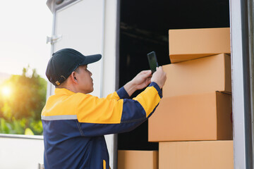 Delivery worker scanning shipment with smartphone in truck during sunset, focus on logistics and efficiency