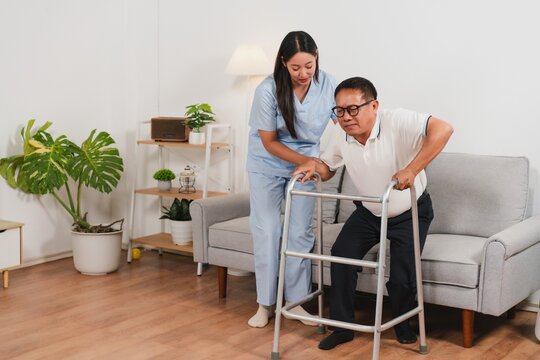 Caring nurse assists elderly man with walker in modern living room setting for rehabilitation and support