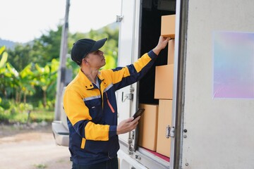 Delivery Person Organizing Packages in Truck with Smartphone in Green Landscape