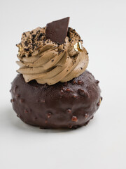 Chocolate choux pastry with chocolate icing on white background
