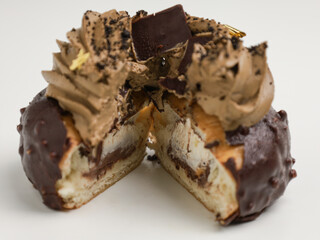Chocolate choux pastry with chocolate icing on white background