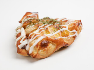 Savory pastry with mayonnaise drizzled on white background