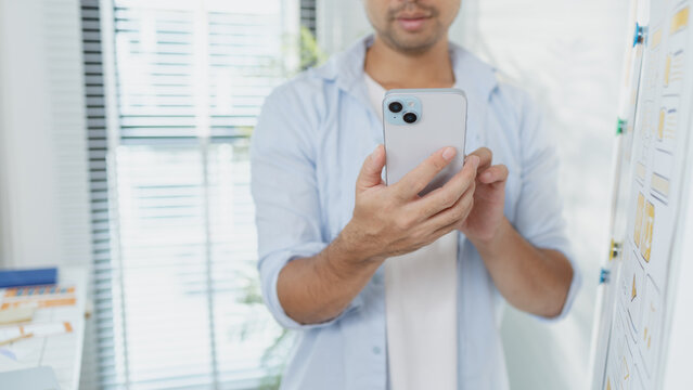 A designer is developing UX UI layouts, reviewing mobile app prototypes, and arranging interface elements on paper and board. He is focused on user experience and digital creativity. - Powered by Adobe