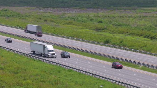 Lorry semi truck delivering cargo in hauling trailer on multilane American freeway.