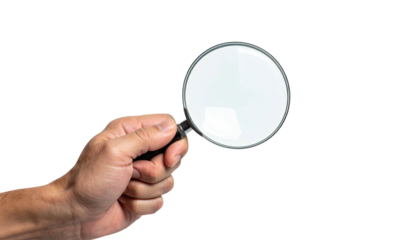 A hand holds a magnifying glass, centered against a black background