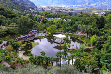 Gardens of Trauttmansdorff Castle panorama with water lily pond, flowers, trees and plants near Merano, South Tyrol, Italy