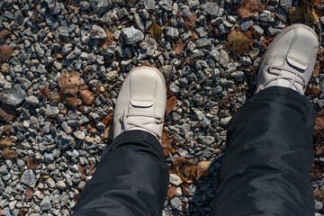Person Wearing Shoes Walking on Gravel.