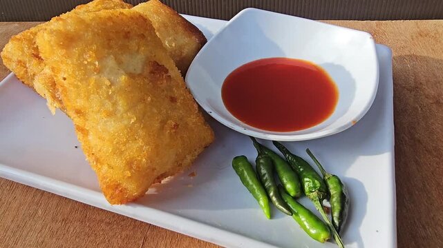 breakfast on the table Risole,Rissoles,Risol is snack fiiled with vegetables,smoked beef,sausage,cheese,mayonnaise sauce,wrapped in risol skin and bread crumbs served with green cayenne pepper and chi
