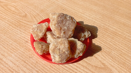 Brown sugar jaggery isolated on wooden background.