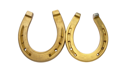 Two golden horseshoes overlapping, isolated on black background; lucky charm symbol