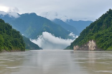 Misty river valley between verdant mountains