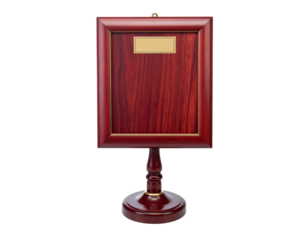 A wooden plaque with a small gold plate and wooden stand against a black background