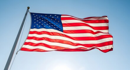 The American flag waves proudly against a clear blue sky on a sunny day.