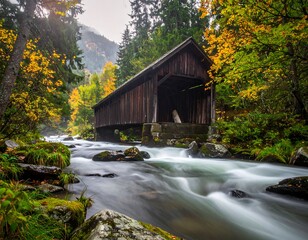 Wooden covered bridge spans a rushing stream in autumn colors