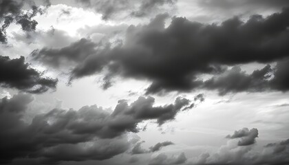 Dramatic black and white image of a cloudy sky filled with dark, ominous storm clouds.