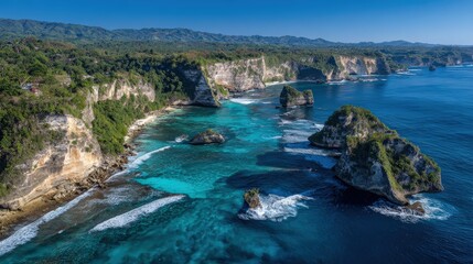 A breathtaking aerial view of rugged cliffs meeting vibrant blue waters, showcasing the natural beauty of a coastal landscape.