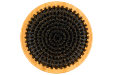 Top view of a round wooden brush with dense black bristles isolated on a transparent background