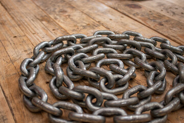 Photograph of thick metal chains placed on a rustic table