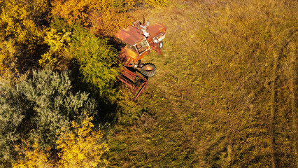 Aerial View of a Rusted, Abandoned Combine Harvester in an Overgrown Field