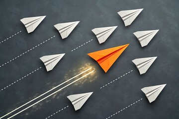 A vibrant orange paper airplane leading a group of white ones, symbolizing innovation and leadership