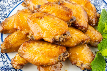 A plate of delicious grilled chicken wings on a white background