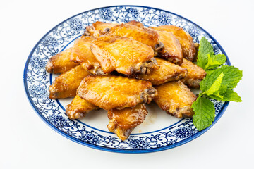 A plate of delicious grilled chicken wings on a white background