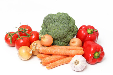 Fresh vegetables assortment on white background. Healthy food ingredients for cooking. Broccoli, carrots, tomatoes, peppers, onion and garlic. Clean eating and vegetarian diet concept.