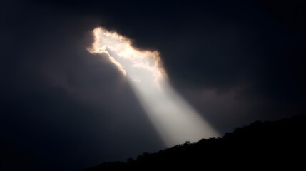 Obraz premium Beam of sunlight breaking through dark storm clouds, illuminating the ground.