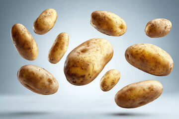 Obraz premium Fresh Floating Potatoes on Blue Background