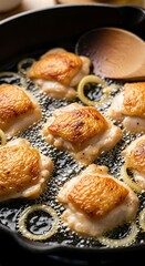 Crispy Chicken Thighs Sizzling in a Cast Iron Pan with Onions.