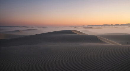 Golden desert sand dunes landscape under dramatic light on the horizon