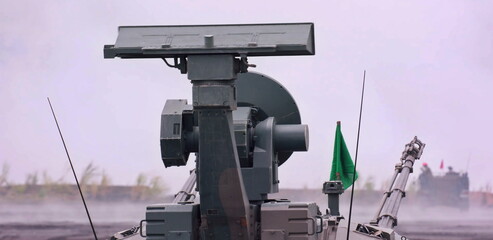 The advanced radar system, likely part of an air defense unit, surveys its surroundings amidst a smoky atmosphere, indicating ongoing operations or training maneuvers.