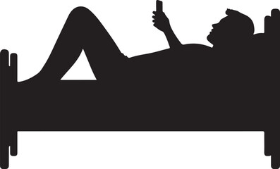 Silhouette of person lying in bed using smartphone